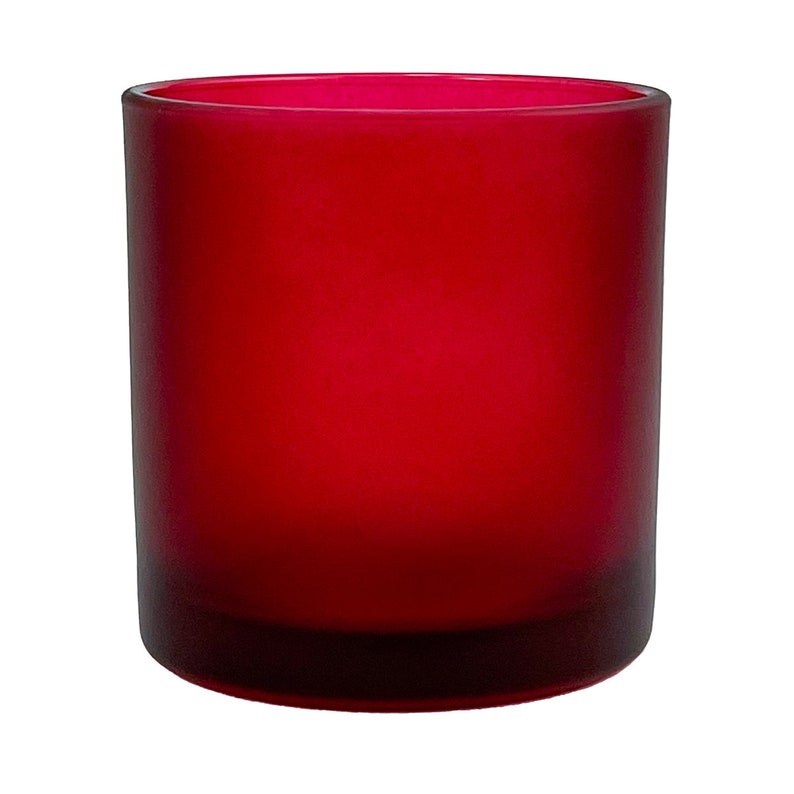 May include: A frosted red glass candle jar with a wide mouth opening. The jar is opaque and has a smooth, rounded bottom.