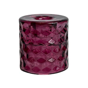 May include: A deep purple glass candle holder with a textured, diamond-shaped pattern.