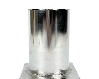 May include: A silver metal candle mold with a square base and a cylindrical top. The mold is made of stainless steel and has a smooth, polished finish.