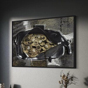 May include: A rectangular wall art piece featuring a black bag filled with gold-coloured Bitcoin coins. The background is a textured abstract mix of black, white, and gold paint strokes. The artwork is enclosed in a thin black frame and mounted.