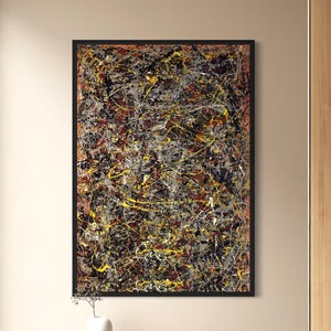 May include: Abstract expressionist painting with a black frame. The artwork features a complex arrangement of splattered and dripped paint in shades of yellow, gray, brown, and black. The painting is displayed in a modern living room setting.