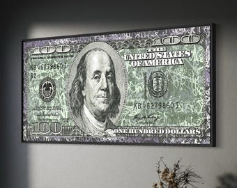 May include: A rectangular wall art piece featuring a stylized, oversized United States one hundred dollar bill with a green and black graffiti-style overlay. The artwork displays the portrait of Benjamin Franklin and the text United States of America.