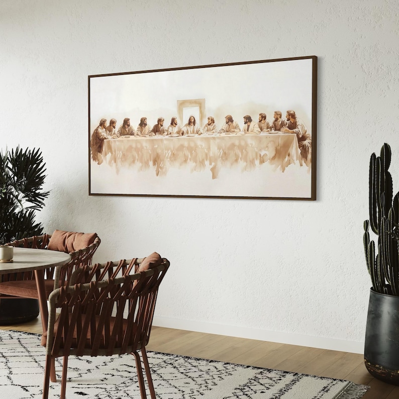 May include: A framed sepia-toned print of The Last Supper, depicting Jesus and his disciples at a table. The artwork is displayed on a white wall, with a brown frame. The room features a table, chairs, a rug, and potted plants, creating a serene atmosphere.