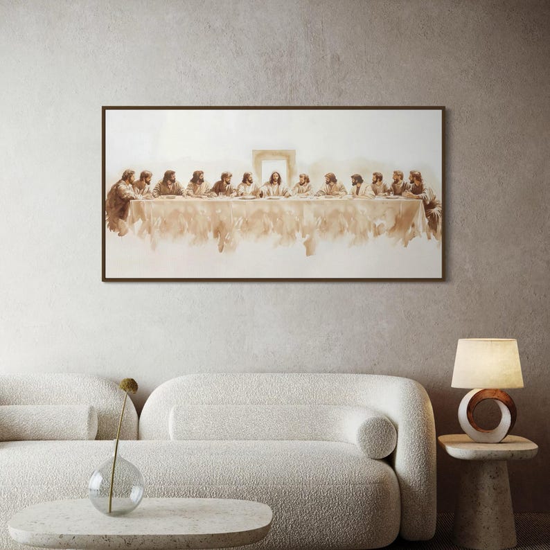 May include: A framed sepia-toned print of The Last Supper, showing Jesus and his disciples at a table. The artwork is displayed above a white sofa in a modern living room setting. The print has a dark brown frame.