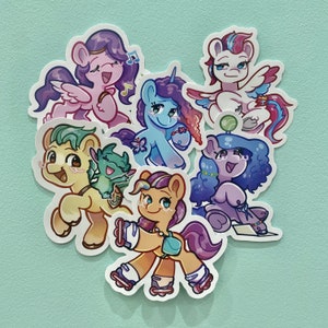May include: A set of colorful cartoon pony stickers featuring a pink pony with a purple mane, a blue pony with a purple mane, a yellow pony with a pink mane, a green dragon, a blue pony with a purple mane, and a pink pony with a blue mane.