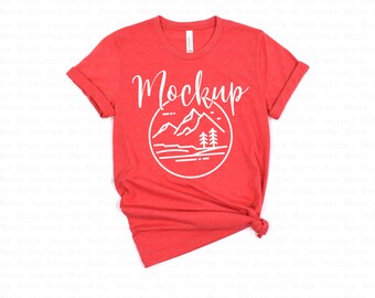 May include: Red t-shirt with a white graphic of mountains and trees in a circle. The text "Mockup" is above the graphic.