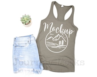 May include: A gray tank top with a white graphic of mountains and trees. The text "Mockup" is written in white cursive above the graphic.