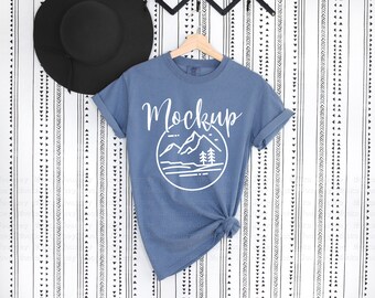 May include: A blue t-shirt with a white mountain graphic and the word "Mockup" on a white background with black geometric patterns.