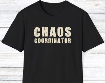 Pode incluir: T-shirt preto com a frase "CHAOS COORDINATOR" impressa em letras brancas desgastadas. A camiseta tem mangas curtas e gola redonda. O texto está centralizado na frente.
