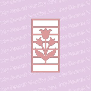 May include: A pink silhouette of a tulip flower with three blooms and leaves, cut out of a rectangular piece of paper. The tulip is centered on the paper and the background is white.