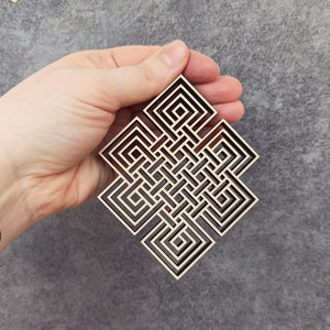 May include: A wooden, geometric, knot design with a dark brown outline and a light brown interior. The knot is a symbol of good luck and eternity.