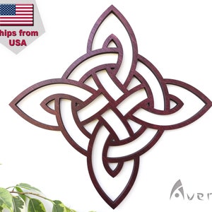 Può includere: Un designo di nodo celtico in legno marrone su sfondo bianco. Il nodo è una stella a quattro punte con dettagli intricati.