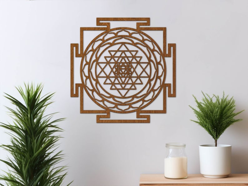 Op de afbeelding: Een bruine houten wanddecoratie met een geometrisch ontwerp. Het ontwerp is een Sri Yantra, een heilig symbool in het hindoe&iuml;sme.
