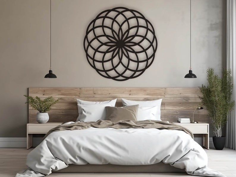 K&ouml;nnte beinhalten: Ein wei&szlig;es Bett mit einem Holz-Kopfteil und einem schwarzen geometrischen Wandbehang dar&uuml;ber. Das Bett hat eine wei&szlig;e Bettdecke und eine braune Wolldecke. Es gibt zwei Nachttische mit Lampen darauf.