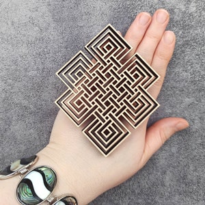 May include: A wooden wall hanging in the shape of a square knot, a traditional symbol of good luck and eternity. The knot is intricately carved with multiple layers of lines, creating a complex and visually appealing design.