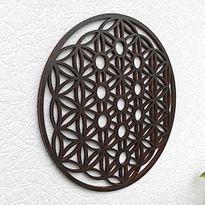May include: A dark brown wooden wall hanging with a geometric pattern, resembling a flower of life mandala.