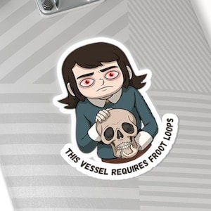 Op de afbeelding: Een sticker met een cartoon illustratie van een persoon die een schedel vasthoudt. De persoon heeft donker haar en draagt een blauwgroene top. De sticker heeft de tekst "THIS VESSEL REQUIRES FROOT LOOPS" in een gebogen ontwerp.
