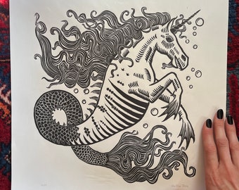 May include: Black and white woodcut print of a seahorse with a unicorn horn and a flowing mane. The seahorse is depicted with a scaly tail and is surrounded by bubbles.