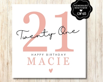 以下が含まれることがあります： ピンクと白の誕生日カードで、大きなピンクのフォントで21という数字が書かれています。 「Twenty One」というテキストは、黒い筆記体で書かれています。 「Happy Birthday Macie」というテキストは、黒いフォントで書かれています。 カードの下部には、小さなピンクのハートがあります。