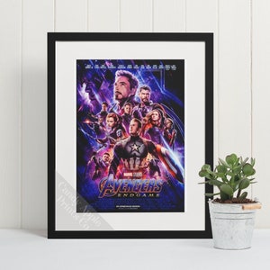 May include: A framed movie poster for the Marvel Cinematic Universe film Avengers: Endgame. The poster features a group of superheroes, including Iron Man, Captain America, Thor, Black Widow, and Hulk, standing in front of a purple and blue background. The text "Avengers: Endgame" is printed in white at the bottom of the poster.
