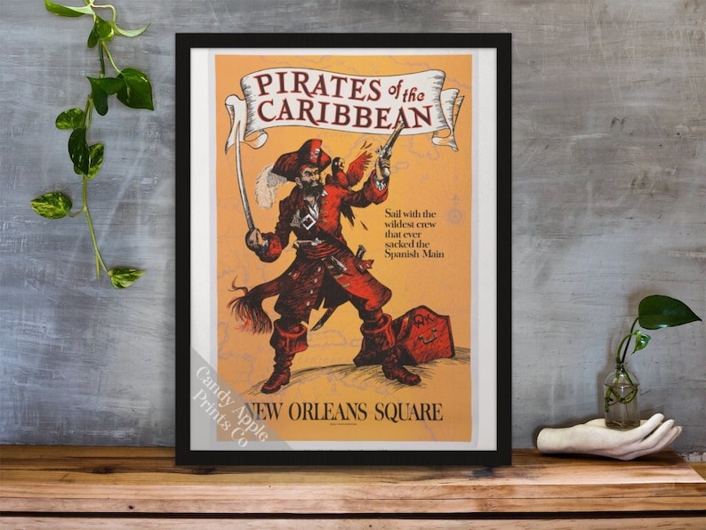May include: A vintage-style poster advertising Pirates of the Caribbean at New Orleans Square. The poster features a cartoon pirate holding a sword and a pistol, with a map of the Caribbean behind him. The text on the poster reads "Pirates of the Caribbean" and "Sail with the wildest crew that ever sacked the Spanish Main."