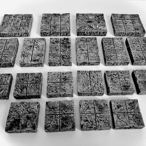 May include: Twenty-four gray stone tiles with a textured surface. The tiles are arranged in four rows of six tiles each.