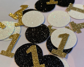 May include: Gold glitter number one confetti on black and white glitter circles.