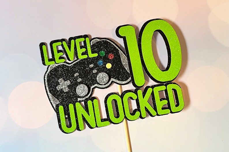 K&ouml;nnte beinhalten: Gr&uuml;ner und schwarzer Tortendekor mit einem Videospiel-Controller und dem Text "Level 10 freigeschaltet".