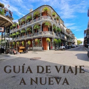 Puede incluir: Una escena de calle en Nueva Orleans, Luisiana, con un edificio colorido con balcones de hierro forjado y exuberante vegetación. El texto "GUÍA DE VIAJE A NUEVA ORLEANS!" está superpuesto a la imagen.