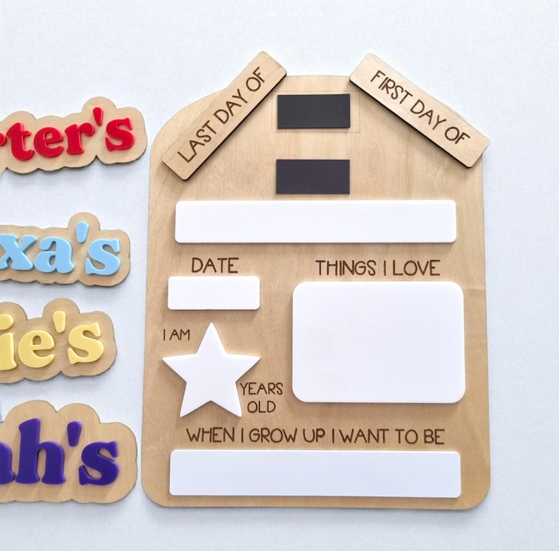 May include: A wooden school board with the text "Last Day Of" and "First Day Of". The board has spaces for "Date", "Things I Love", "I Am", "Years Old", and "When I Grow Up I Want To Be". There are also name tags.