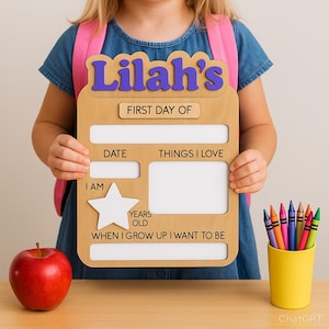 May include: A wooden sign with the name "Lilah's" in purple letters, designed for the first day of school. The sign includes spaces for the date, things loved, and a photo. A red apple and a yellow cup of crayons are also visible.