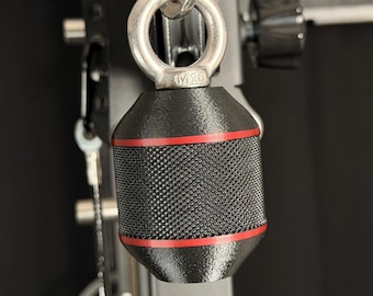 May include: A black cylindrical gym attachment with a textured knurled grip surface and two thin red horizontal stripes. The handle is connected to a silver metal eye bolt with the text M10 clearly visible on the base of the ring attachment.