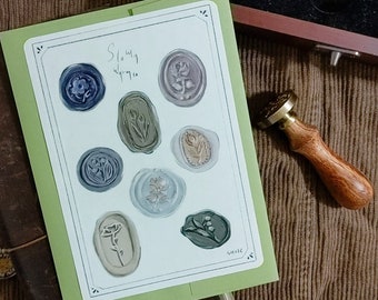 Könnte beinhalten: Eine grüne Karte mit dem Text "Slowly" und "wither" darauf. Die Karte hat mehrere Wachssiegel mit floralen Designs in verschiedenen Grüntönen, Blau- und Brauntönen.