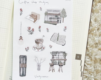 May include: A set of nine illustrated stickers featuring a coffee shop theme. The stickers include a coffee shop storefront, a cup of coffee, a book, a pair of scissors, a vase with flowers, a light fixture, and two chairs. The stickers are in a watercolor style with a light brown and beige color palette.