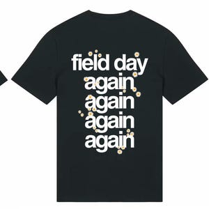 May include: Black t-shirt with the text "field day again again again again again" in white on the back. The front of the shirt has two small white squares. The shirt is a crew neck.