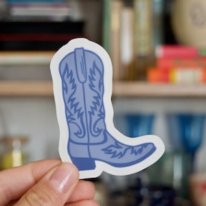 May include: A blue cowboy boot sticker with a detailed design. The sticker is on a white background.