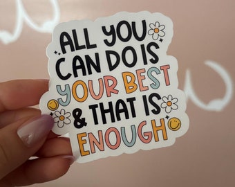 Puede incluir: Una pegatina blanca con texto de colores que dice "Todo lo que puedes hacer es dar lo mejor de ti y eso es suficiente". El texto está rodeado de pequeñas flores e ilustraciones de caritas sonrientes.