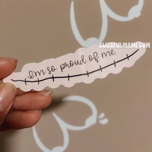 May include: A pink sticker with a black line and the text "I'm so proud of me."