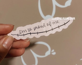 May include: A pink sticker with a black line and the text "I'm so proud of me."