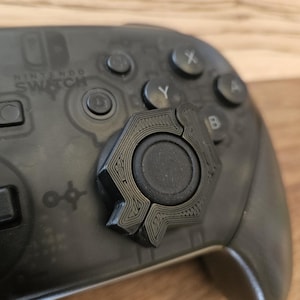 May include: A set of three ceramic mugs with a speckled, matte finish. The mugs are in shades of cream, light gray, and dark gray. Each mug has a simple, minimalist design, perfect for coffee or tea.