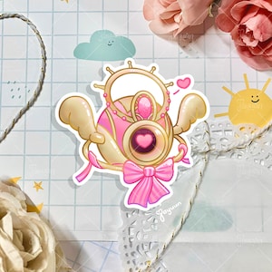 May include: A pink and gold carriage with wings, a heart-shaped window, and a pink bow. The carriage is decorated with gold trim and a pink heart.