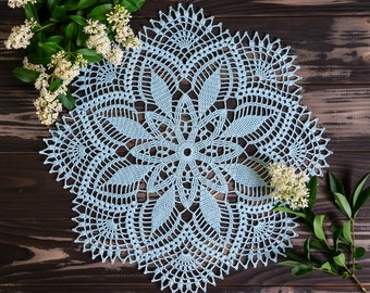 Round light blue crochet doily with fans