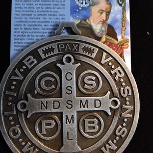 Medal of Saint Benedict in gray metal measuring 4x4 inches brings the prayer.