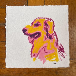 May include: A square art print on textured white paper featuring a stylized illustration of a dog in profile. The dog is rendered in vibrant shades of yellow, pink, and deep purple with visible crayon-like strokes and a signature in the corner.