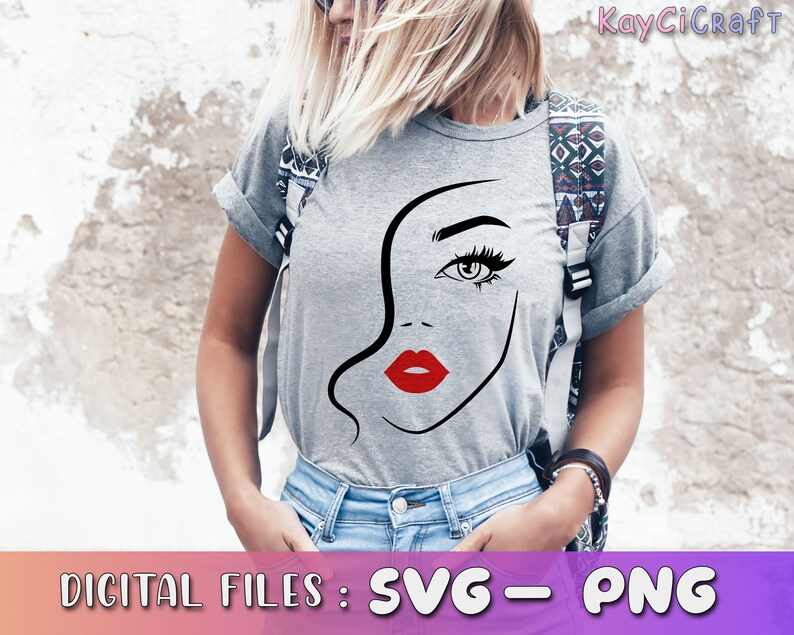 May include: A gray t-shirt with a black and white line drawing of a woman's face with red lips. The woman's eye is visible and has a black eyelash. The t-shirt is being worn by a person with blonde hair.