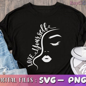 May include: Black t-shirt with a white graphic design of a woman's face and the text "Love Yourself".