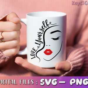 May include: White ceramic mug with a black and white illustration of a woman's face and the text "LOVE YOURSELF" in black cursive lettering. The woman's lips are red.