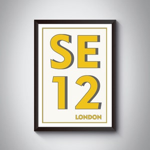 Peut inclure: Une impression encadrée avec un fond blanc et un cadre noir. L'impression présente le texte "SE12 LONDON" en jaune et gris.