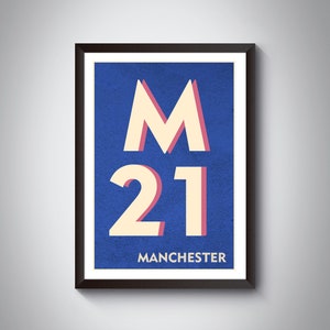 Könnte beinhalten: Ein gerahmtes Poster mit blauem Hintergrund und weißem Text. Der Text lautet "M 21 MANCHESTER". Das "M" ist in einer großen, stilisierten Schriftart und die "21" in einer kleineren, stilisierten Schriftart.