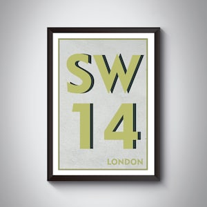 May include: A framed print with a white background and black text. The text reads "SW14 LONDON" in a bold, sans-serif font. The "SW14" is in a larger font size than "LONDON". The "SW14" is outlined in black and filled in with a light green color.
